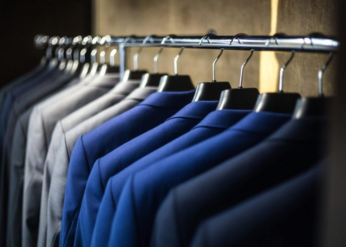 Close-up of neatly arranged suits in a wardrobe, showcasing fashion and organization.