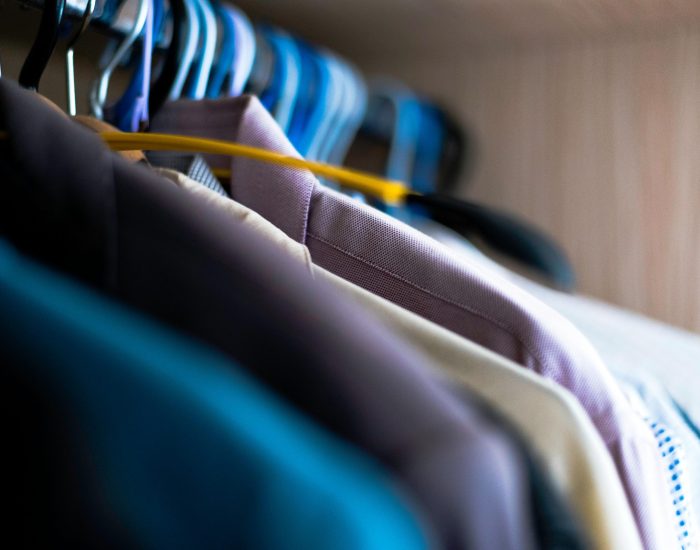 pexels-photo-965632-965632 Close-up of various shirts hanging on colorful hangers inside a wardrobe.
